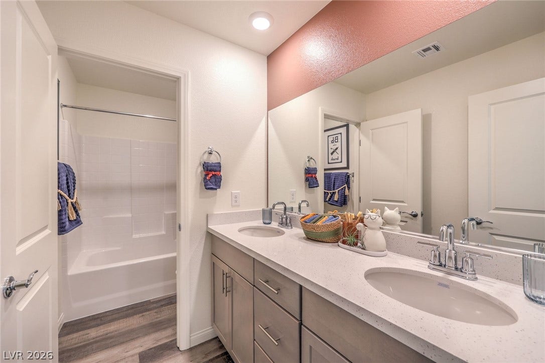 1030 PEACOCK PLUME Avenue, Henderson, NV 89011 Photo is representational only; actual home finishes may vary. Full bathroom with wood finished floors, double vanity, and shower / washtub combination