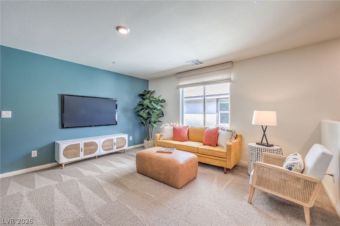 1030 PEACOCK PLUME Avenue, Henderson, NV 89011 Photo is representational only; actual home finishes may vary. Carpeted living room with baseboards