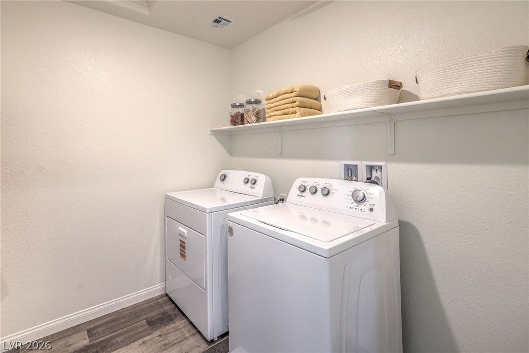 1030 PEACOCK PLUME Avenue, Henderson, NV 89011 Washer and Dryer are not included. Photo is representational only; actual home finishes may vary. Laundry room featuring washer and dryer, wood finished floors, and baseboards