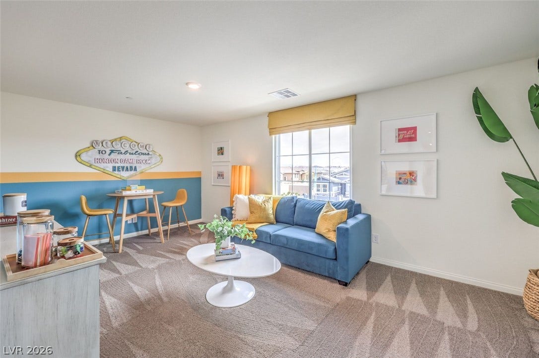 Carpeted living area with baseboards and visible .Photos are of a model home and are for representational purposes only.