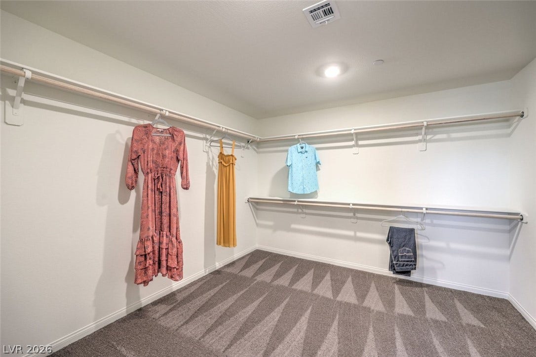Spacious closet with carpet floors and visible vents.Photos are of a model home and are for representational purposes only.