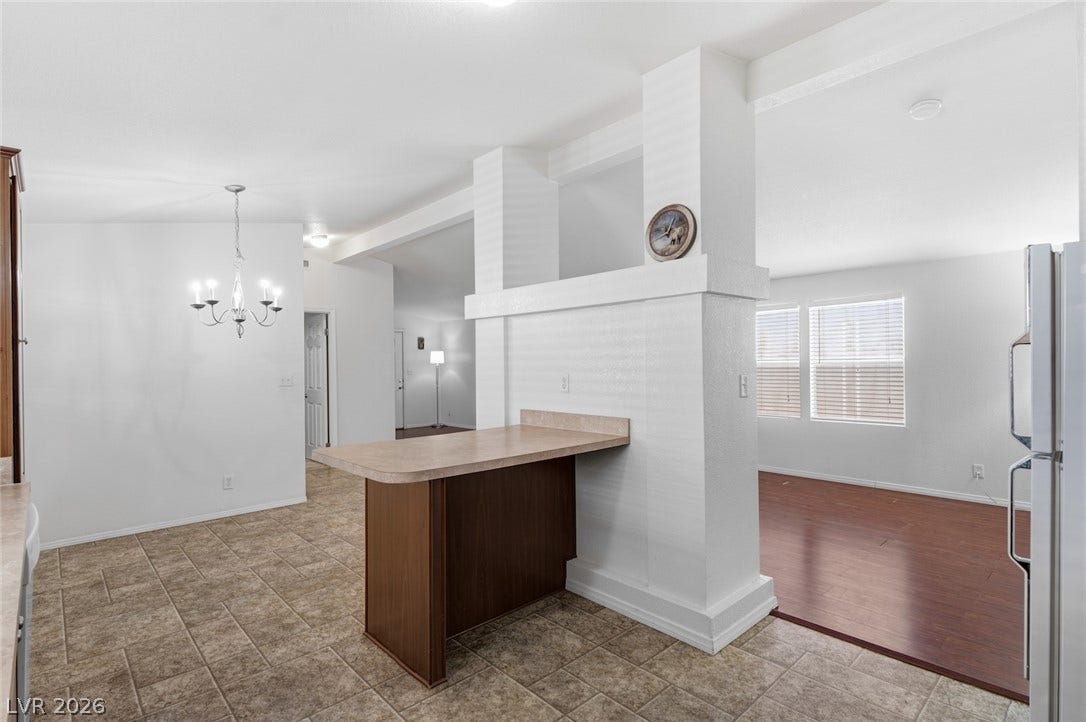 4589 Royal Ridge Boulevard, Las Vegas, NV 89103 A versatile interior space features a convenient dining bar and diverse flooring options, creating an inviting atmosphere.