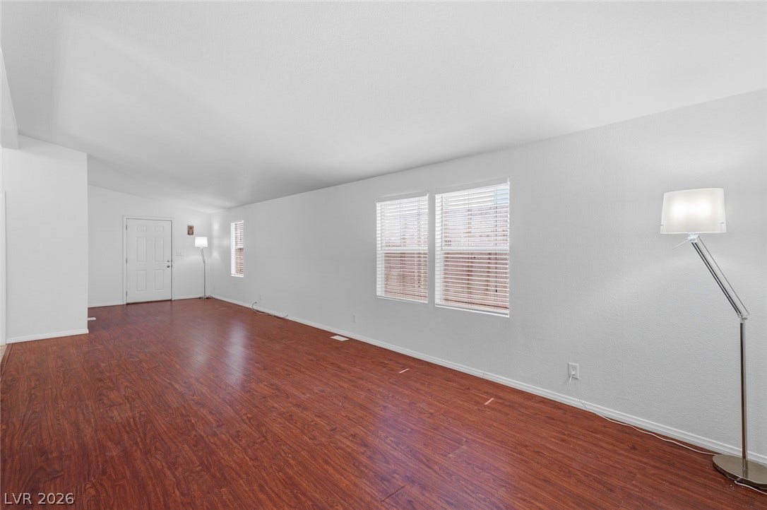 4589 Royal Ridge Boulevard, Las Vegas, NV 89103 Rich hardwood floors flow through this spacious living area, offering a clean canvas for your personal touch.