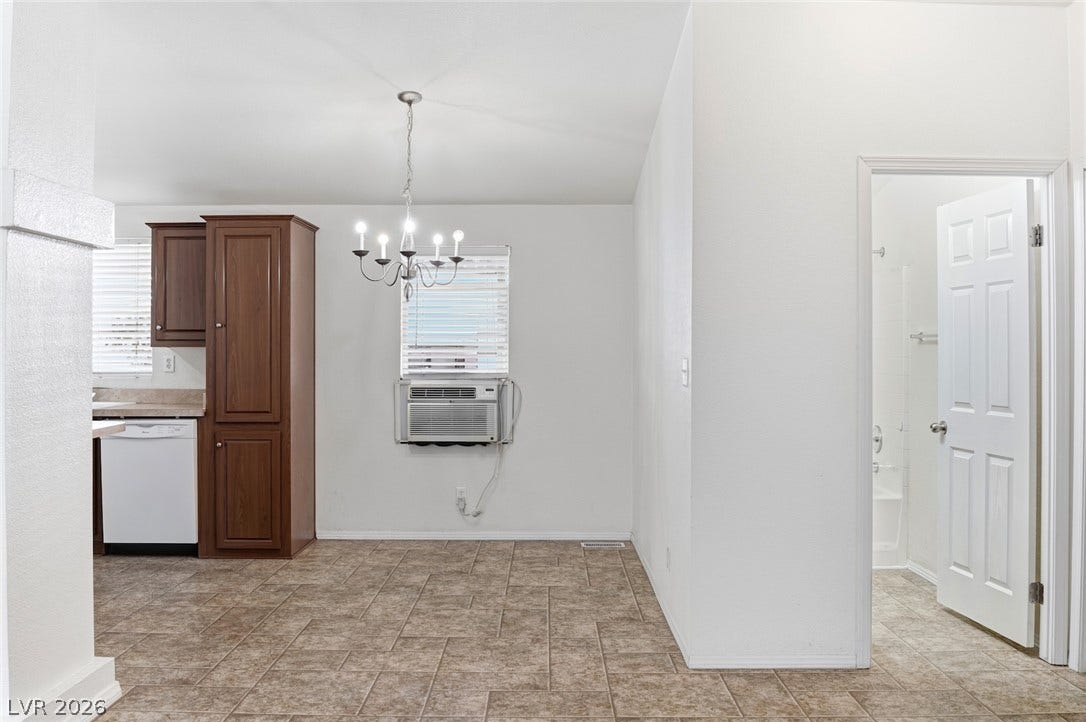 4589 Royal Ridge Boulevard, Las Vegas, NV 89103 Functional kitchen and dining area with easy-care tiled flooring, illuminated by a classic chandelier.