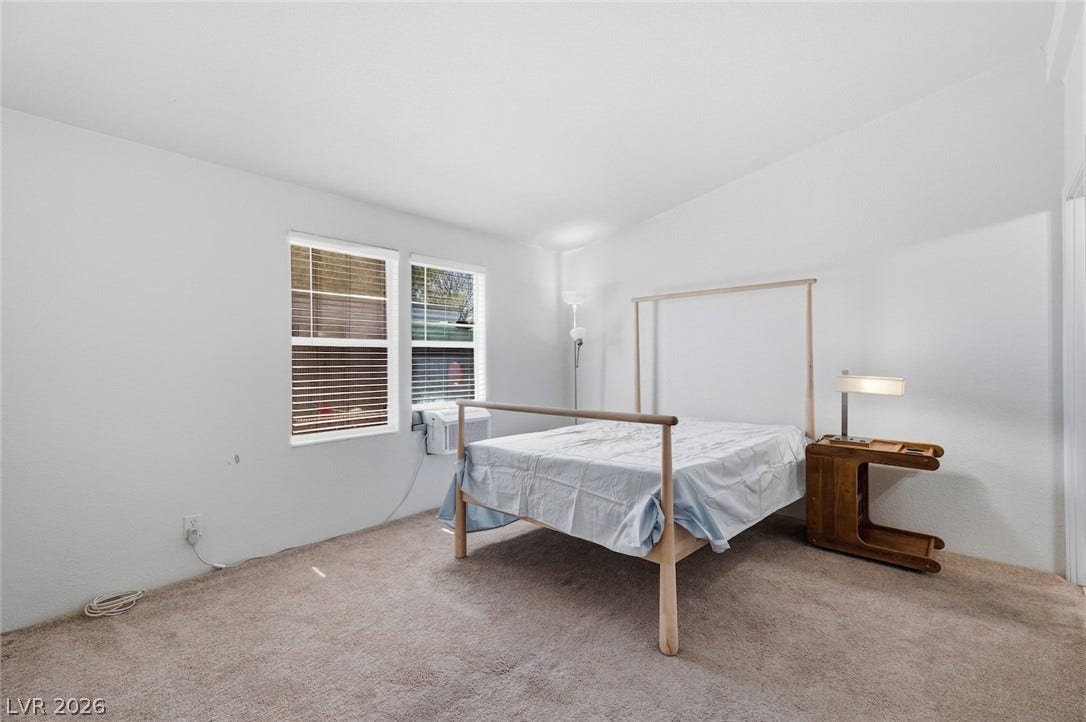 4589 Royal Ridge Boulevard, Las Vegas, NV 89103 Well-lit sleeping quarters with dual windows and plush carpeting for comfort.