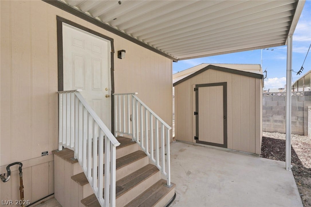 4589 Royal Ridge Boulevard, Las Vegas, NV 89103 A sheltered entry with steps leads to the home, accompanied by a practical storage shed.