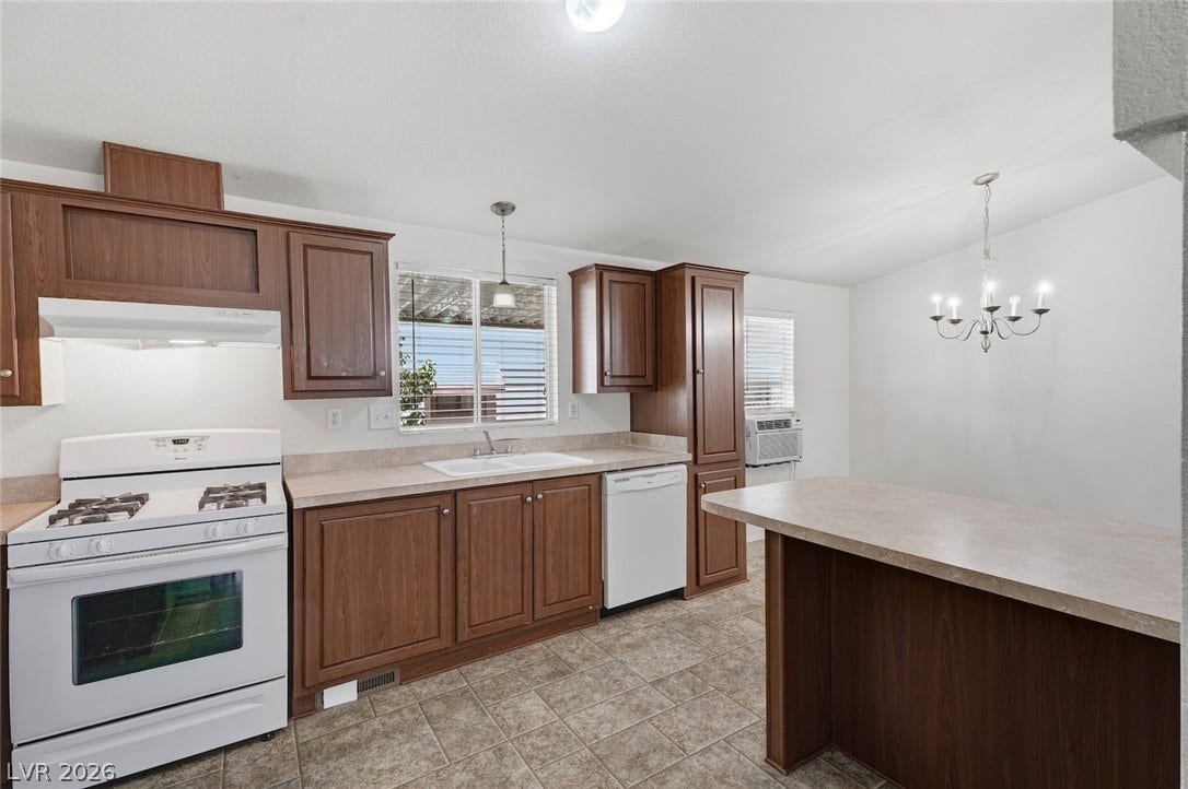 4589 Royal Ridge Boulevard, Las Vegas, NV 89103 Functional kitchen offers ample cabinetry, a white gas range, and a dining bar for casual dining.