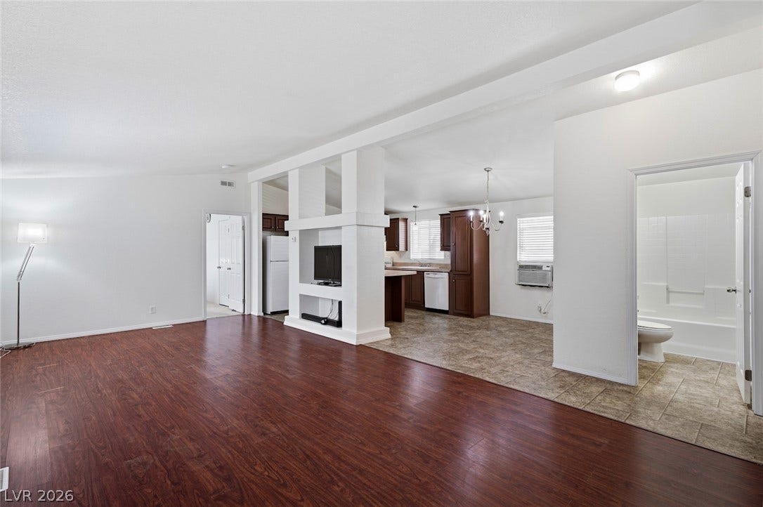 4589 Royal Ridge Boulevard, Las Vegas, NV 89103 An inviting open-concept layout connects the well-lit living area to a practical kitchen, featuring warm wood cabinetry.