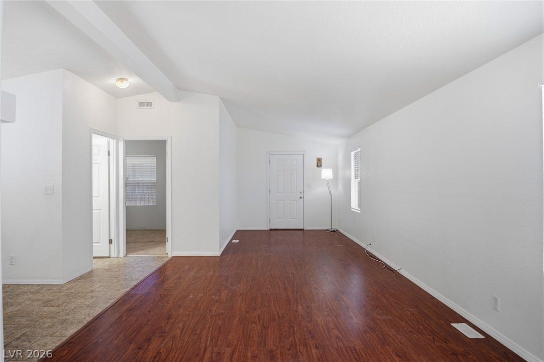 4589 Royal Ridge Boulevard, Las Vegas, NV 89103 Rich wood-look flooring extends through this airy living space, leading to a bright entry door.