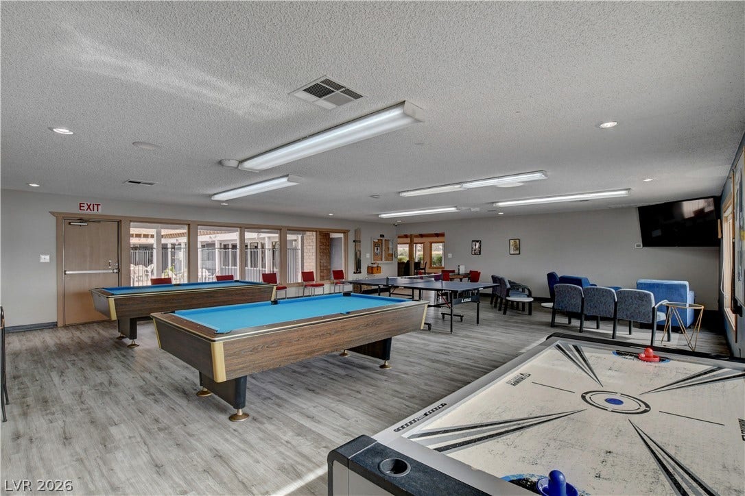 4589 Royal Ridge Boulevard, Las Vegas, NV 89103 A vibrant game room offers endless entertainment with pool tables, a ping pong table, and air hockey.