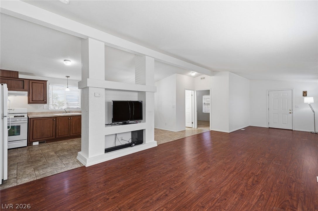 4589 Royal Ridge Boulevard, Las Vegas, NV 89103 An open-concept living space with lustrous wood flooring transitions seamlessly into a well-appointed kitchen.