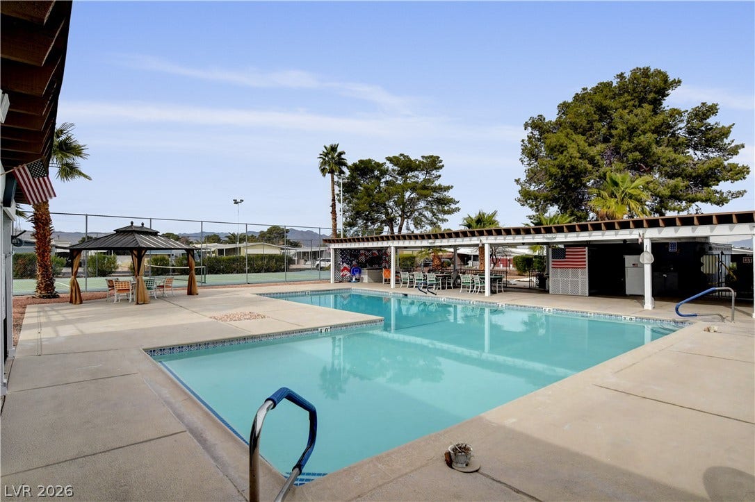 4589 Royal Ridge Boulevard, Las Vegas, NV 89103 A refreshing outdoor pool area offers ample space for relaxation and entertaining, complemented by a shaded pergola and nearby tennis courts.