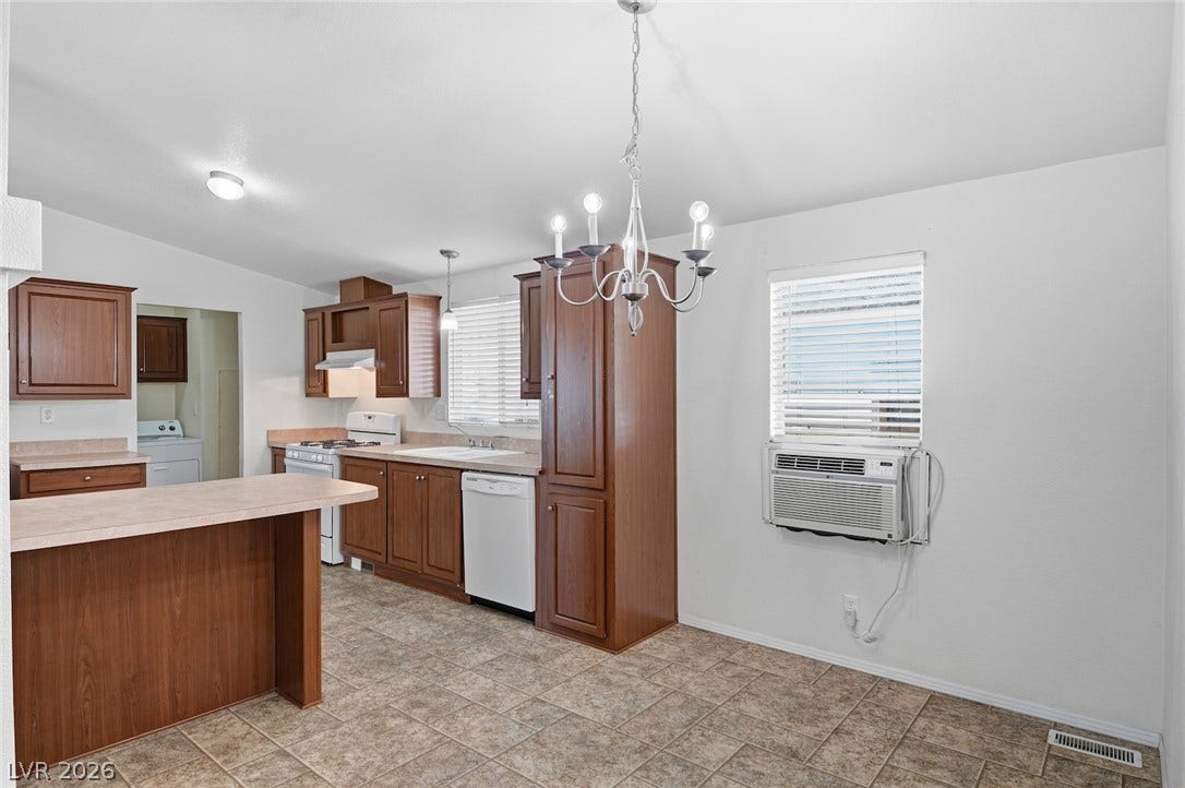 4589 Royal Ridge Boulevard, Las Vegas, NV 89103 A well-equipped kitchen features abundant cabinetry, a practical dining bar, and durable tiled flooring.