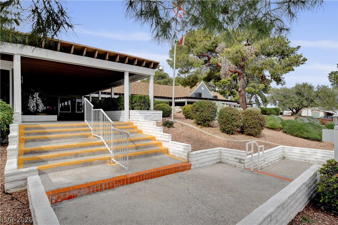 4589 Royal Ridge Boulevard, Las Vegas, NV 89103 A welcoming covered entrance with concrete steps and railings, nestled amongst mature trees and landscaping.
