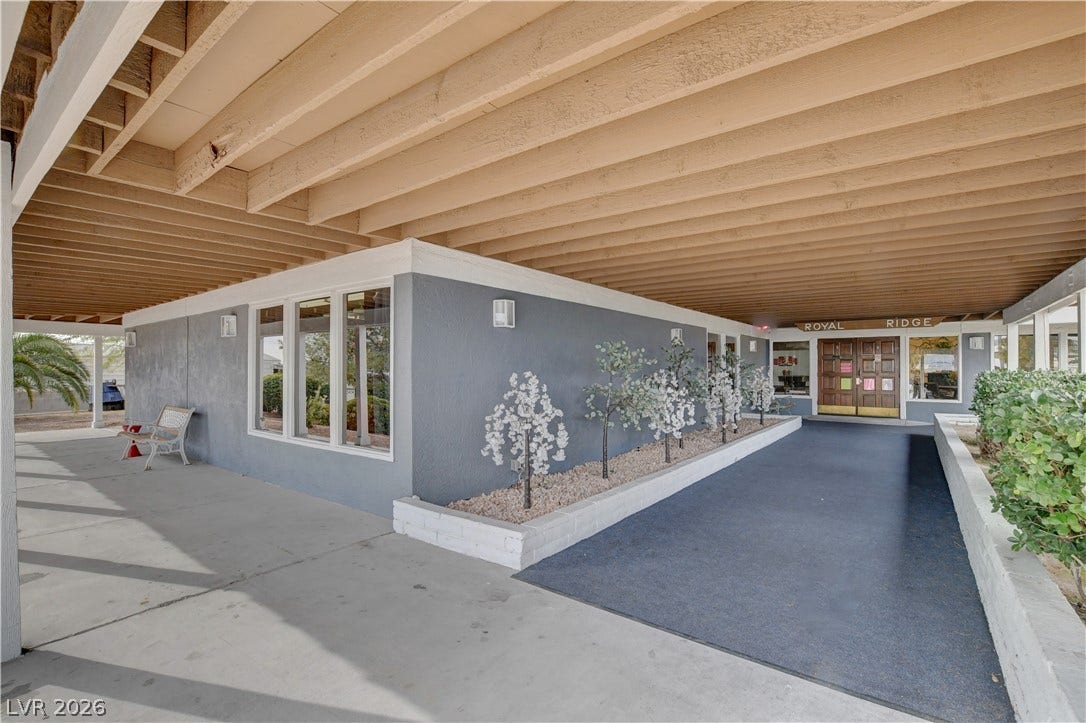 4589 Royal Ridge Boulevard, Las Vegas, NV 89103 A welcoming covered entrance features a clean concrete pathway and well-maintained planters, offering a pleasant approach.