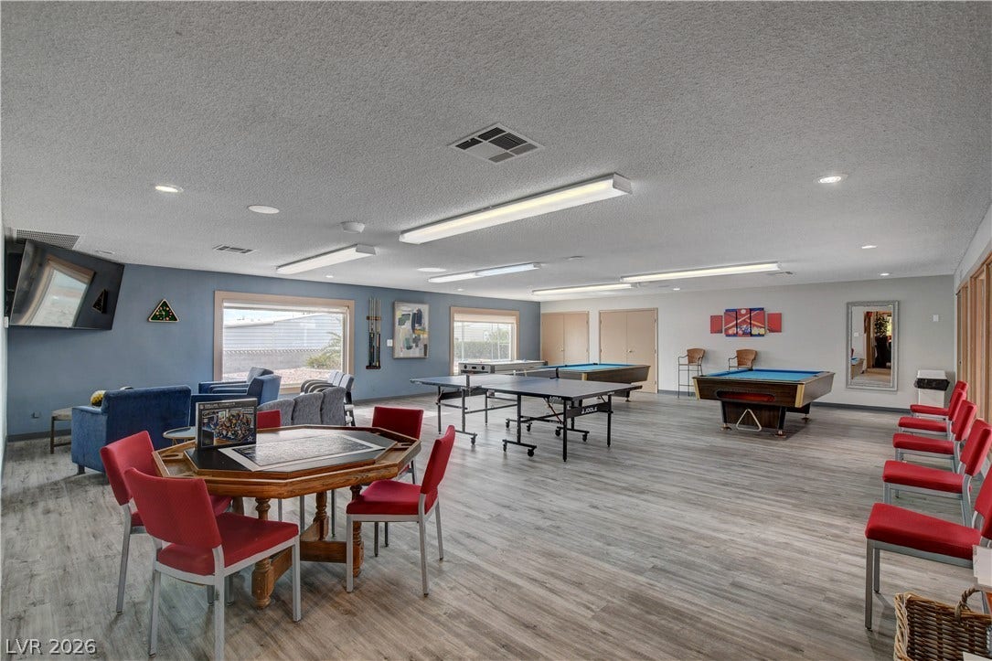 4589 Royal Ridge Boulevard, Las Vegas, NV 89103 An inviting recreation room with multiple game tables and a comfortable lounge area awaits leisure and entertainment.