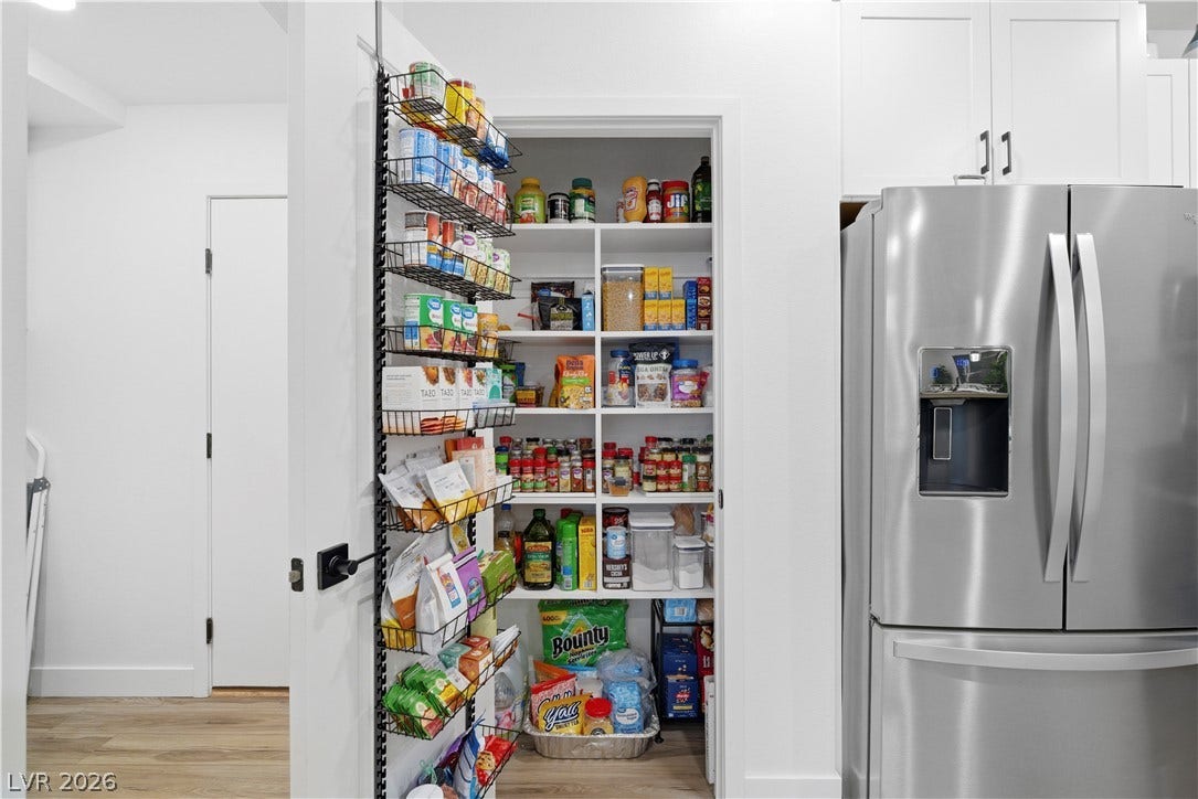 A well-organized pantry featuring ample shelving for optimal storage, seamlessly integrating into the kitchen space.