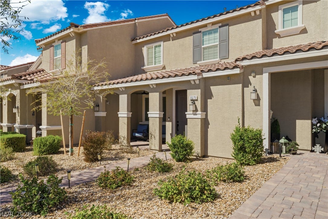 A welcoming facade showcases clean stucco and inviting tile roofing, complemented by a low-maintenance landscape.