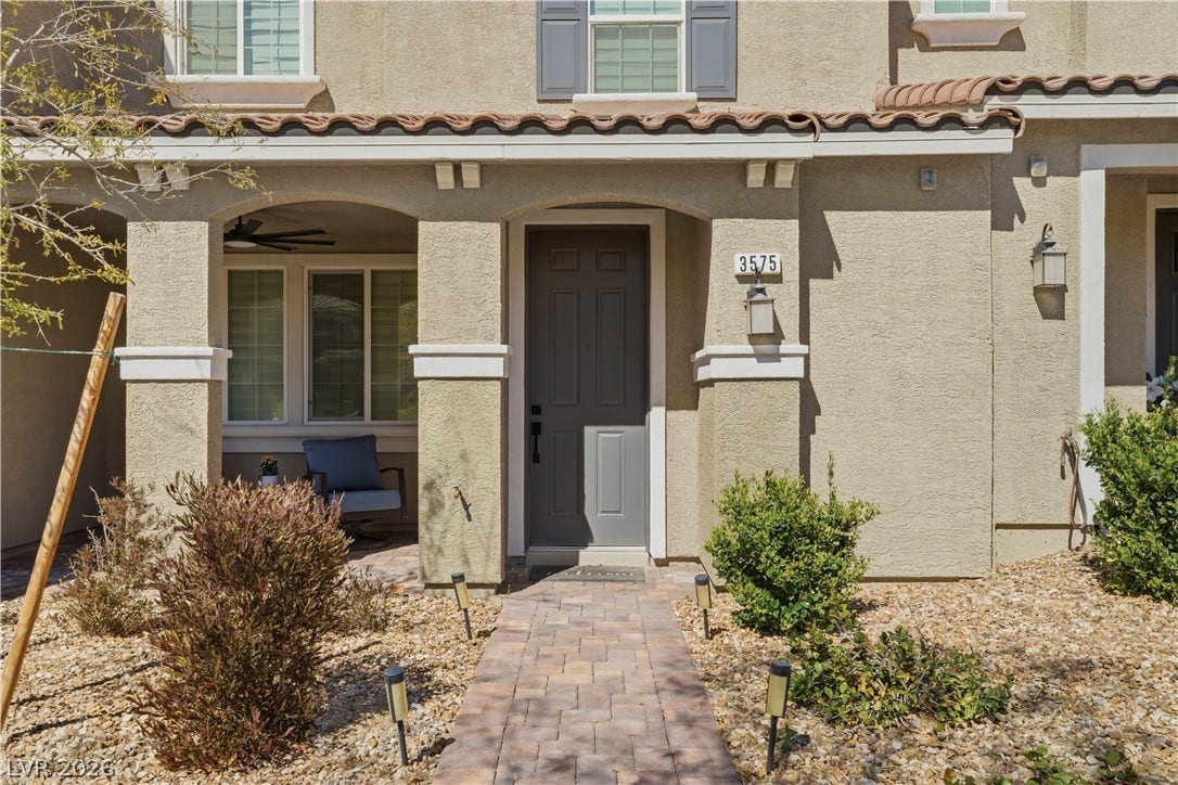 A welcoming brick paver pathway guides guests to the entry of this attractive residence.