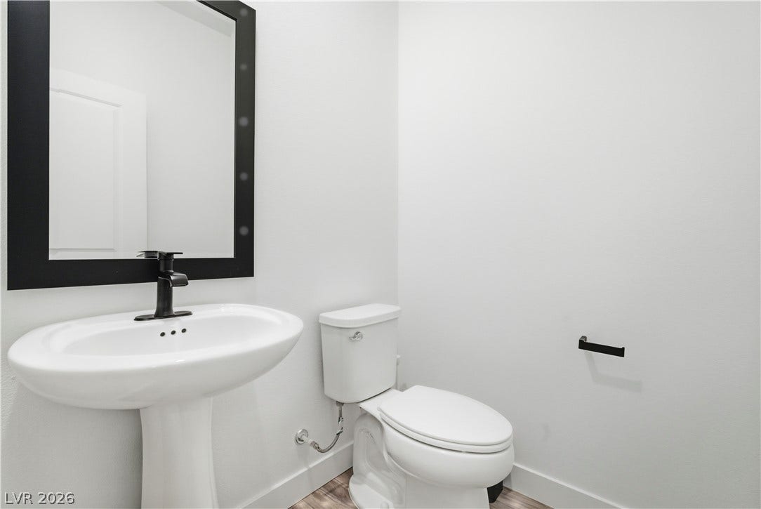 A well-lit powder room showcases a modern pedestal sink and contemporary fixtures.