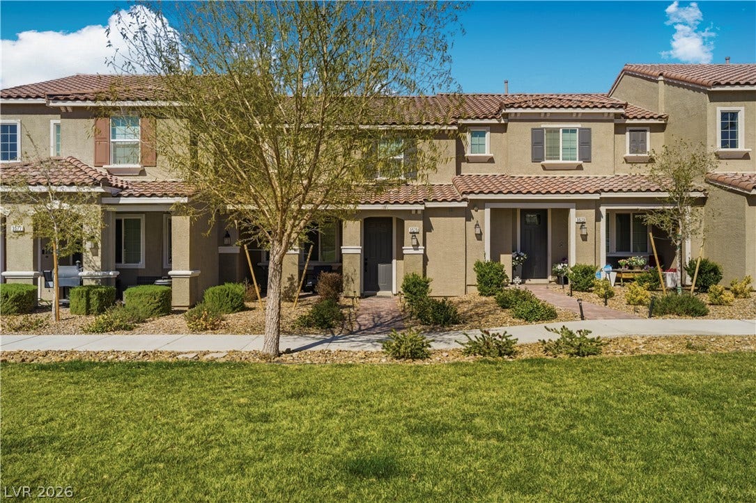 A row of modern townhouses presents inviting front entrances with neat landscaping and accessible sidewalks.