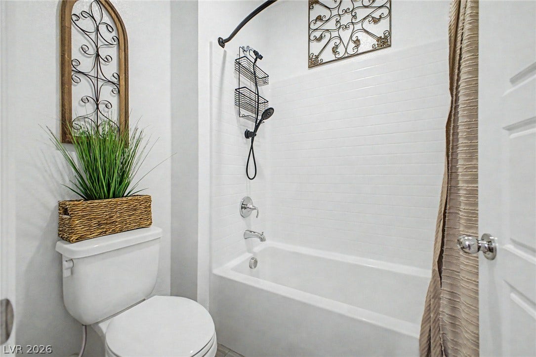 290 Fossil Falls Street, Henderson, NV 89015 A pristine bath features a shower/tub combination with white subway tile, adjacent to a neatly placed toilet.