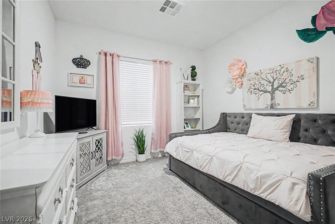 290 Fossil Falls Street, Henderson, NV 89015 A well-lit bedroom provides comfort and serenity, featuring plush carpeting and a wide window.