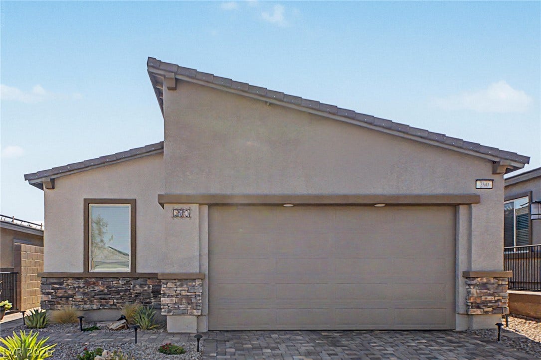 290 Fossil Falls Street, Henderson, NV 89015 A modern stucco facade with striking stone accents and a paver driveway enhance this home's curb appeal.