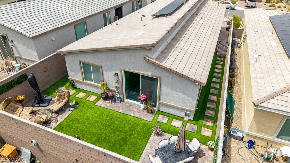 290 Fossil Falls Street, Henderson, NV 89015 A private backyard oasis features lush artificial turf, paver patios, and ample space for outdoor entertaining.