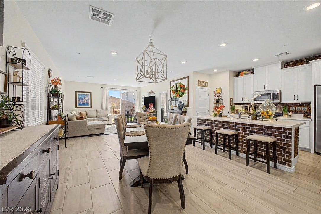 290 Fossil Falls Street, Henderson, NV 89015 An open-concept living space integrates a dining area, kitchen island with breakfast bar, and comfortable lounge, all illuminated by recessed lighting.
