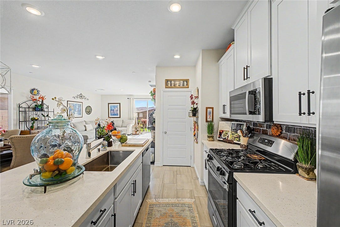 290 Fossil Falls Street, Henderson, NV 89015 A well-lit kitchen with stone counters and a gas range connects seamlessly to an inviting living area.