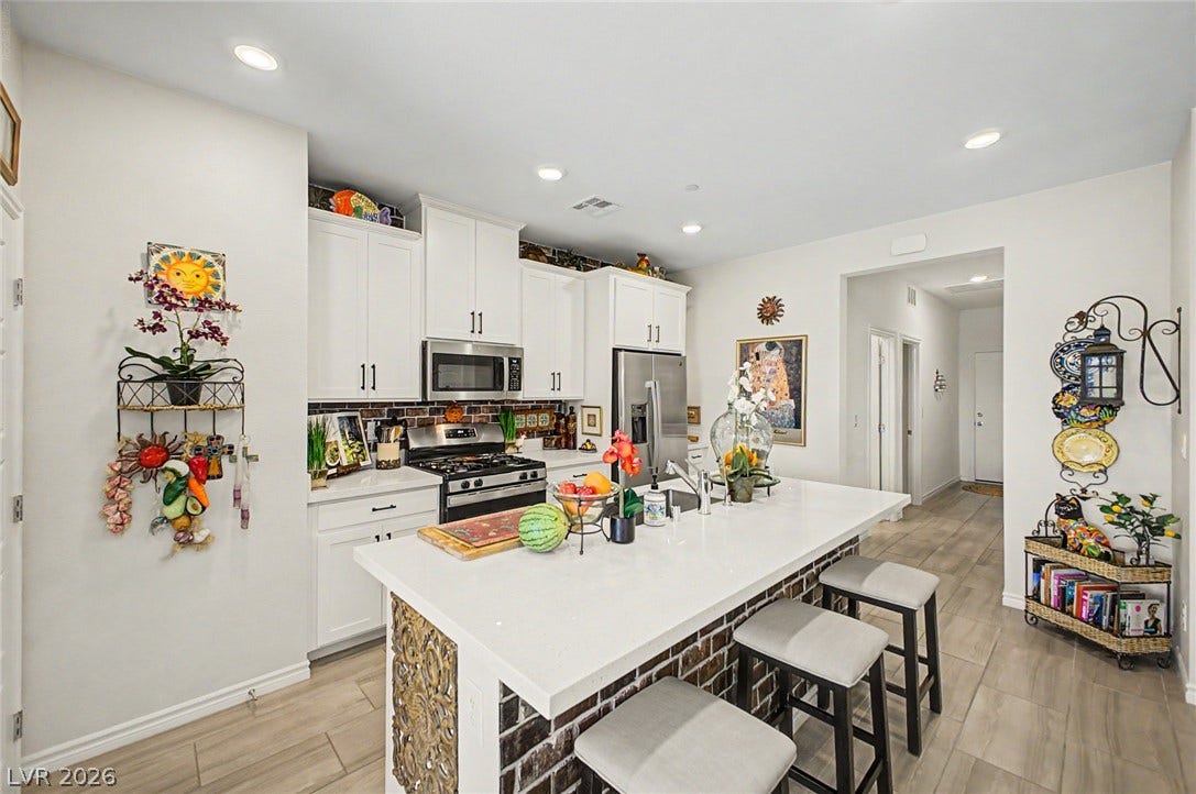 290 Fossil Falls Street, Henderson, NV 89015 A well-appointed kitchen features a central island, stainless steel appliances, and ample white cabinetry.