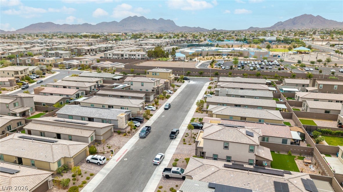 290 Fossil Falls Street, Henderson, NV 89015 An aerial perspective reveals a modern residential community nestled against a distant mountain range.