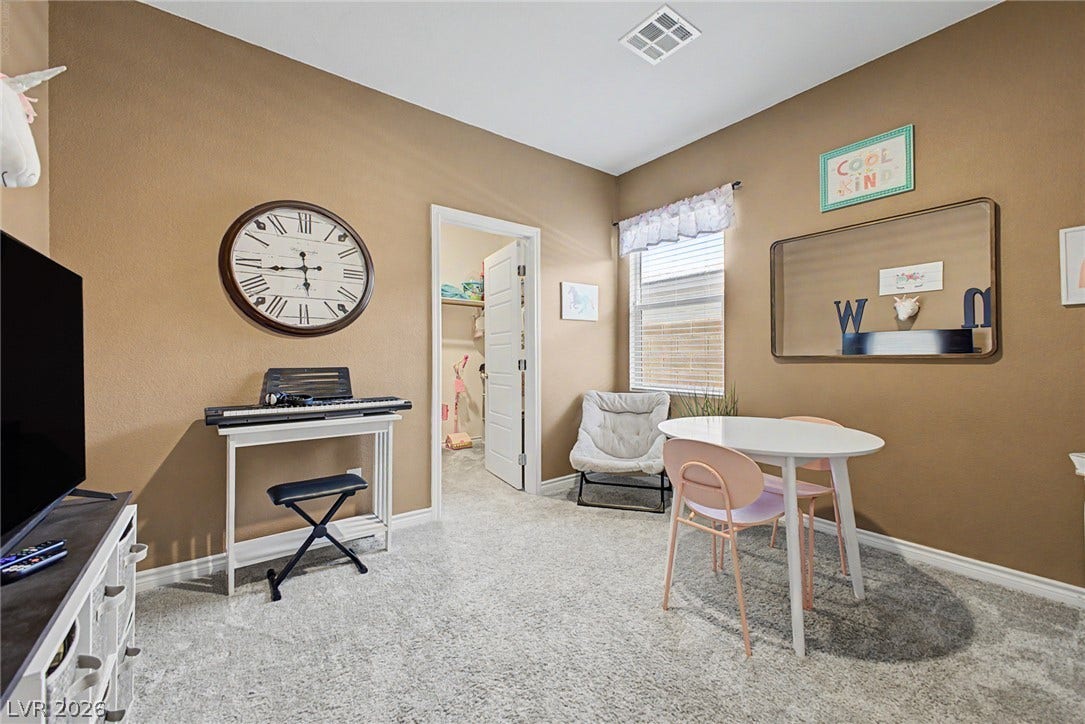 290 Fossil Falls Street, Henderson, NV 89015 A well-lit bedroom with soft carpeting and natural light filtering through the window, offering a cozy retreat.