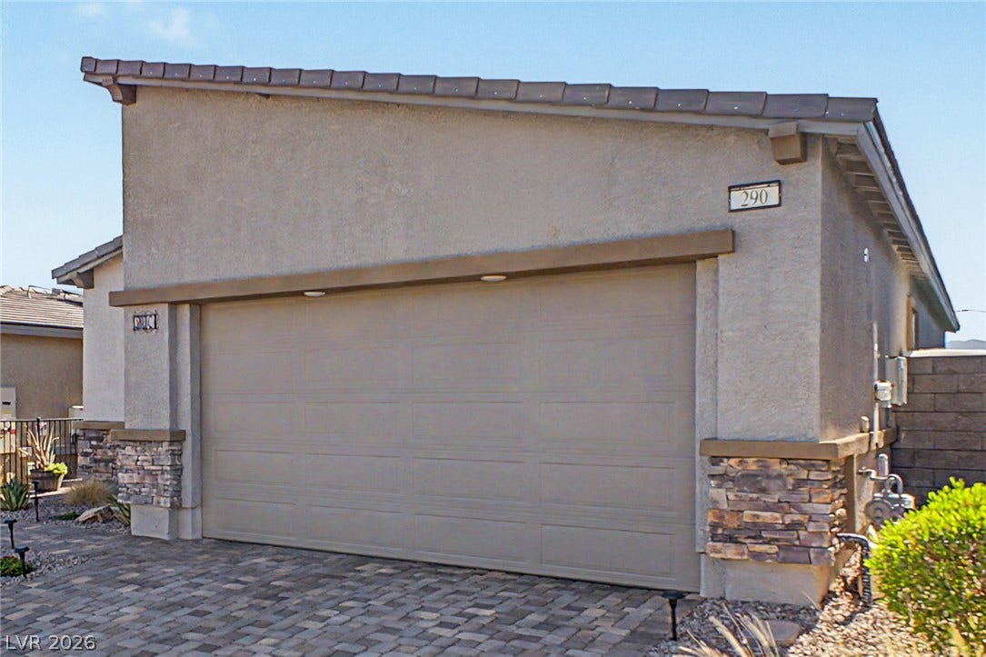 290 Fossil Falls Street, Henderson, NV 89015 A broad paver driveway leads to this home's garage, accented with stone siding.