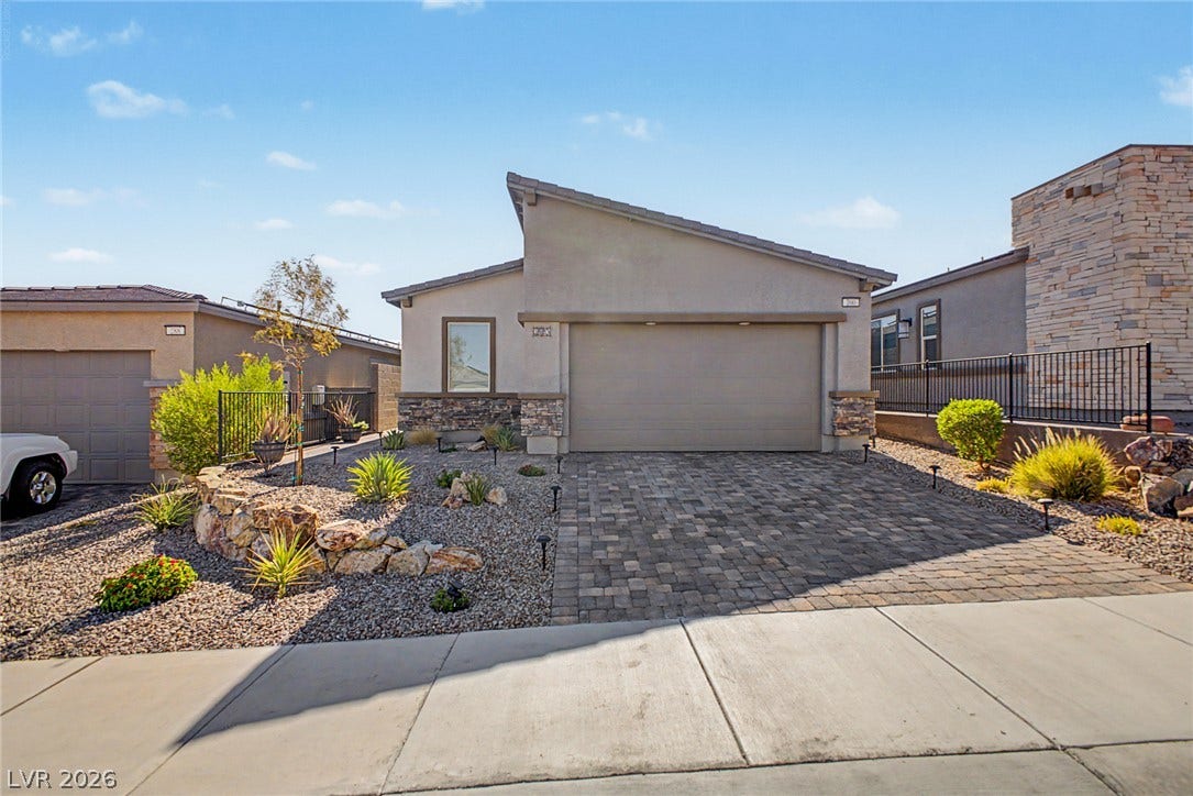 290 Fossil Falls Street, Henderson, NV 89015 A modern facade with striking stone accents and a paver driveway creates compelling curb appeal.