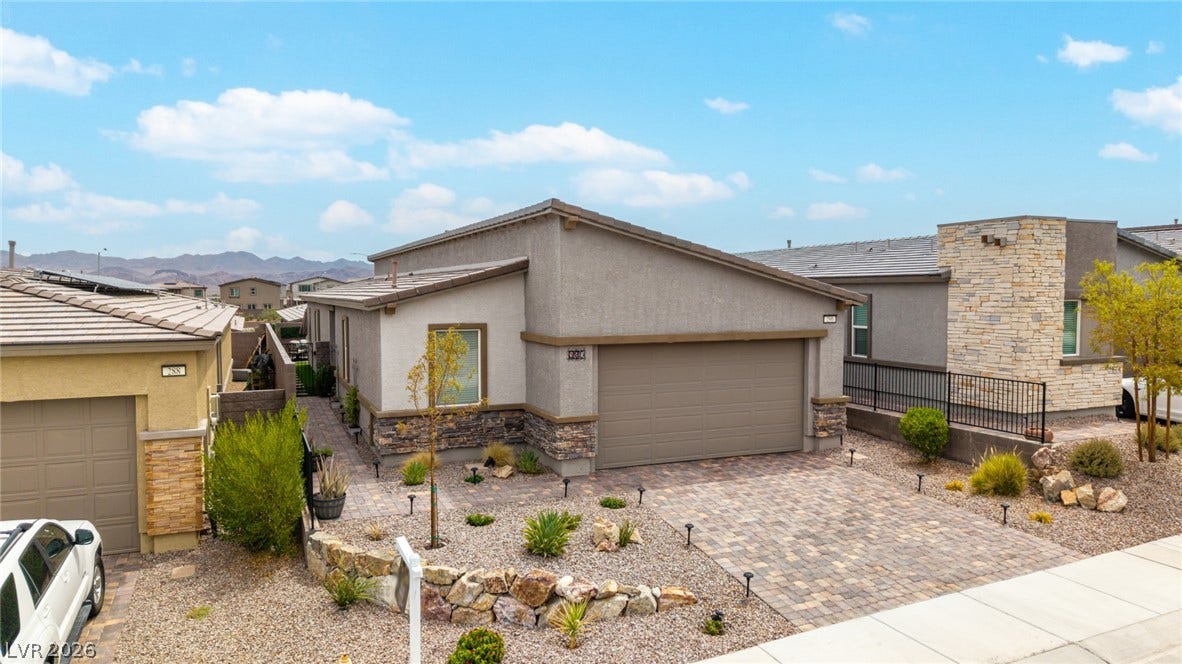 290 Fossil Falls Street, Henderson, NV 89015 A welcoming desert landscape adorns the home's stone and stucco facade, complementing the paver driveway.