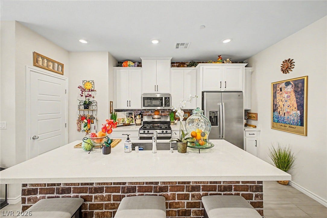 290 Fossil Falls Street, Henderson, NV 89015 Culinary delights await in this bright kitchen, complete with a brick-front island and stainless steel appliances.