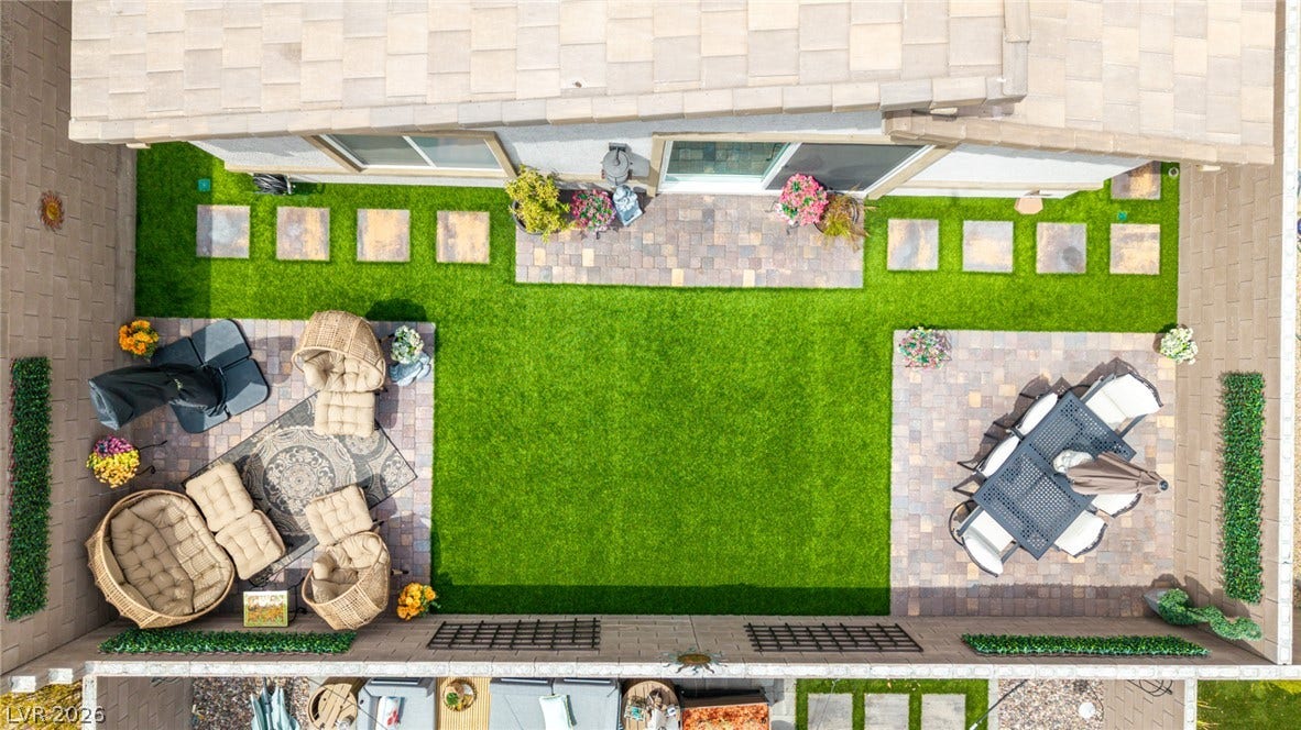 290 Fossil Falls Street, Henderson, NV 89015 An aerial view showcases a meticulously landscaped yard, featuring verdant artificial turf and elegant paver patios.