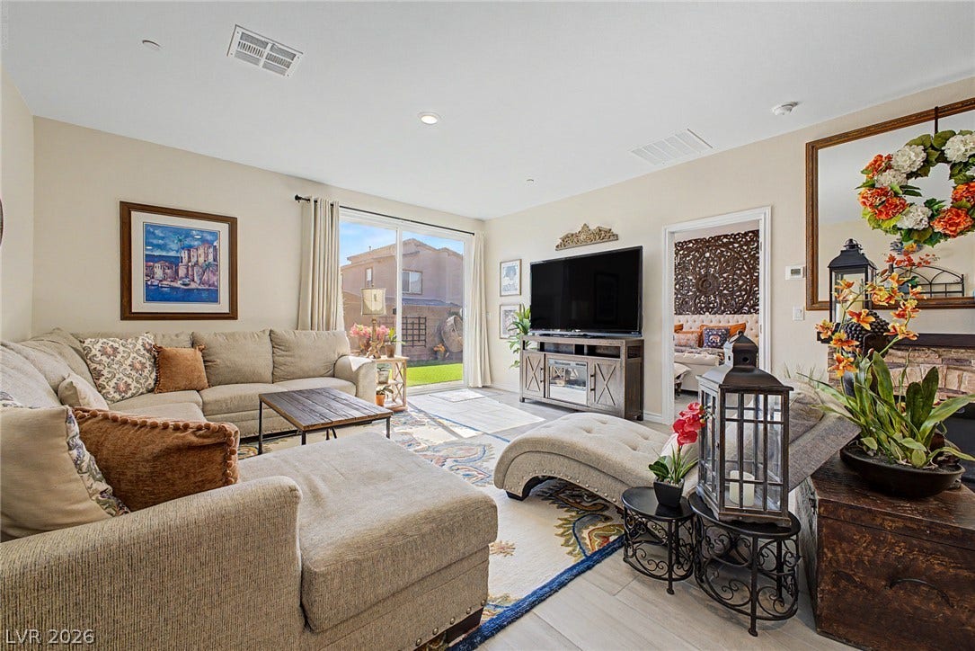 290 Fossil Falls Street, Henderson, NV 89015 Natural light floods this inviting living space, connecting seamlessly to a private yard through a sliding glass door.