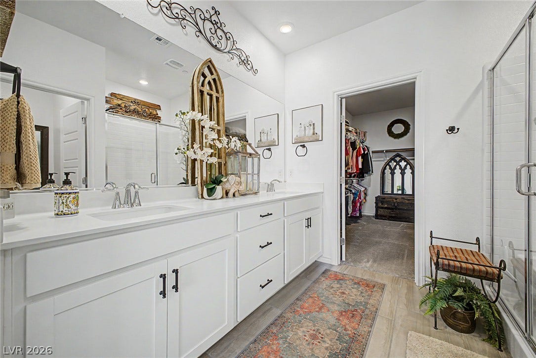 290 Fossil Falls Street, Henderson, NV 89015 A well-lit primary bathroom with dual sinks and a spacious walk-in closet.