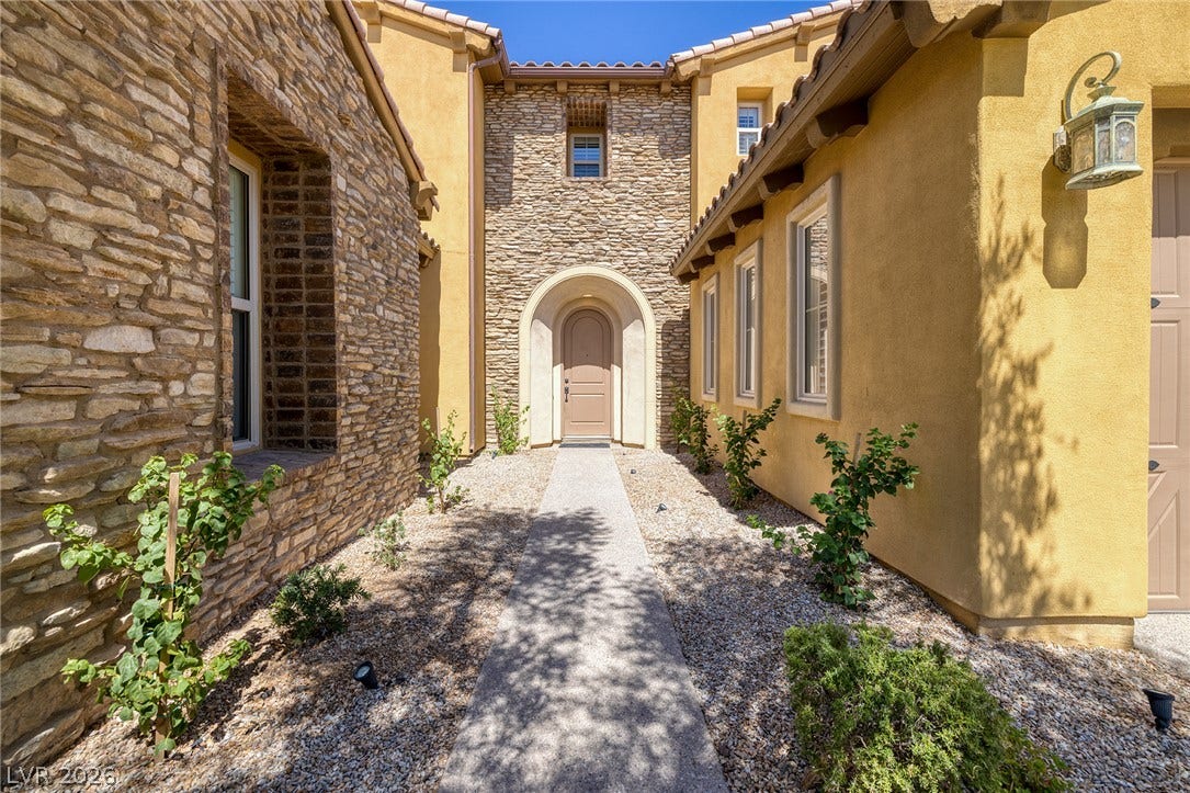 30 Benevolo Drive, Henderson, NV 89011 A stone-accented facade and arched entryway create a welcoming impression.