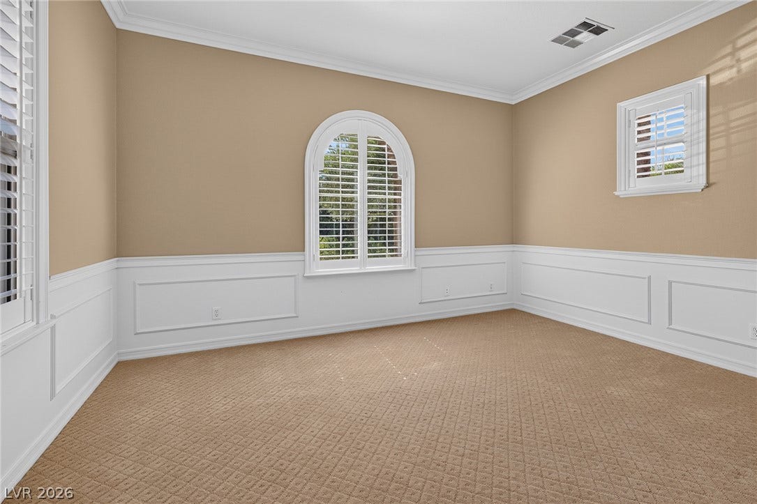 30 Benevolo Drive, Henderson, NV 89011 Well-appointed bedroom showcasing elegant wainscoting and natural illumination through plantation-shuttered windows.
