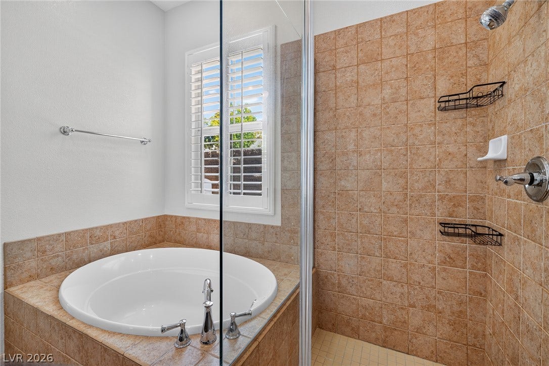 30 Benevolo Drive, Henderson, NV 89011 Luxurious bathroom offering a generous soaking tub alongside a tiled shower enclosure.