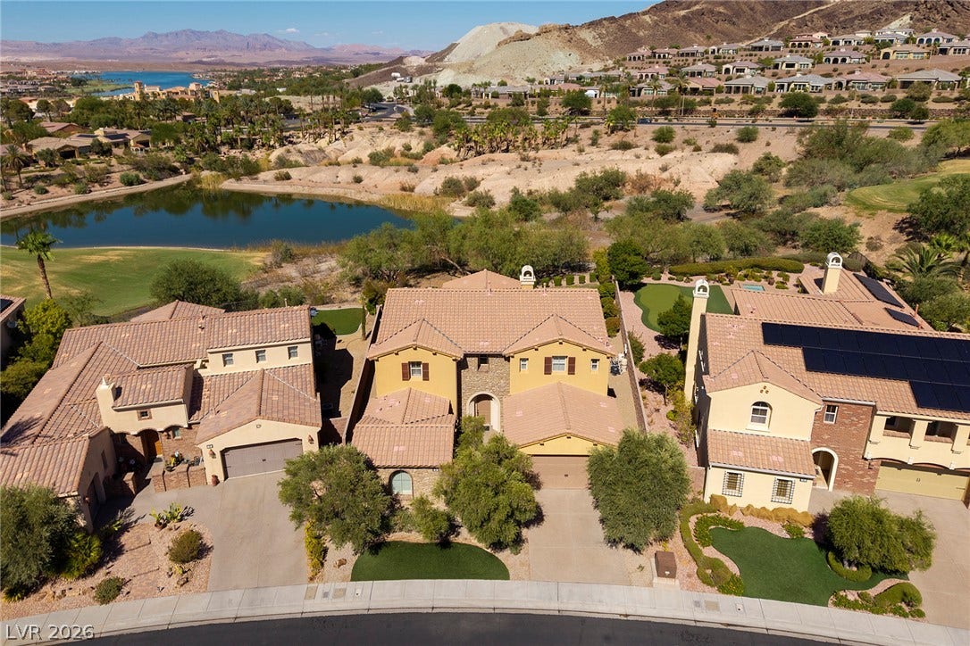 30 Benevolo Drive, Henderson, NV 89011 An aerial perspective reveals a Mediterranean-inspired home, boasting a terra cotta roof, lush landscaping, and a putting green.