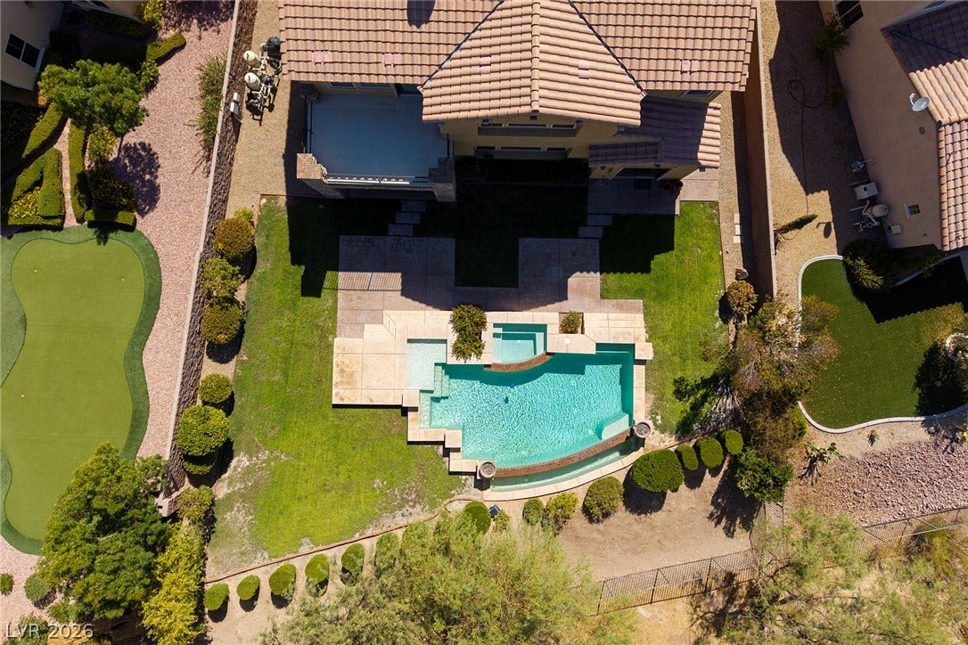 30 Benevolo Drive, Henderson, NV 89011 An aerial view showcases a property with a pristine pool, a private putting green, and manicured landscaping.