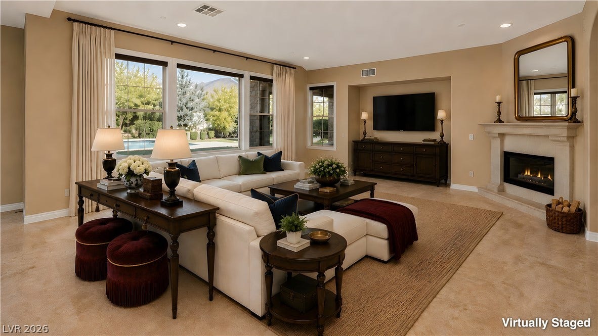 30 Benevolo Drive, Henderson, NV 89011 A refined living space offers ample natural illumination and a comforting fireplace with views of the outdoor pool.