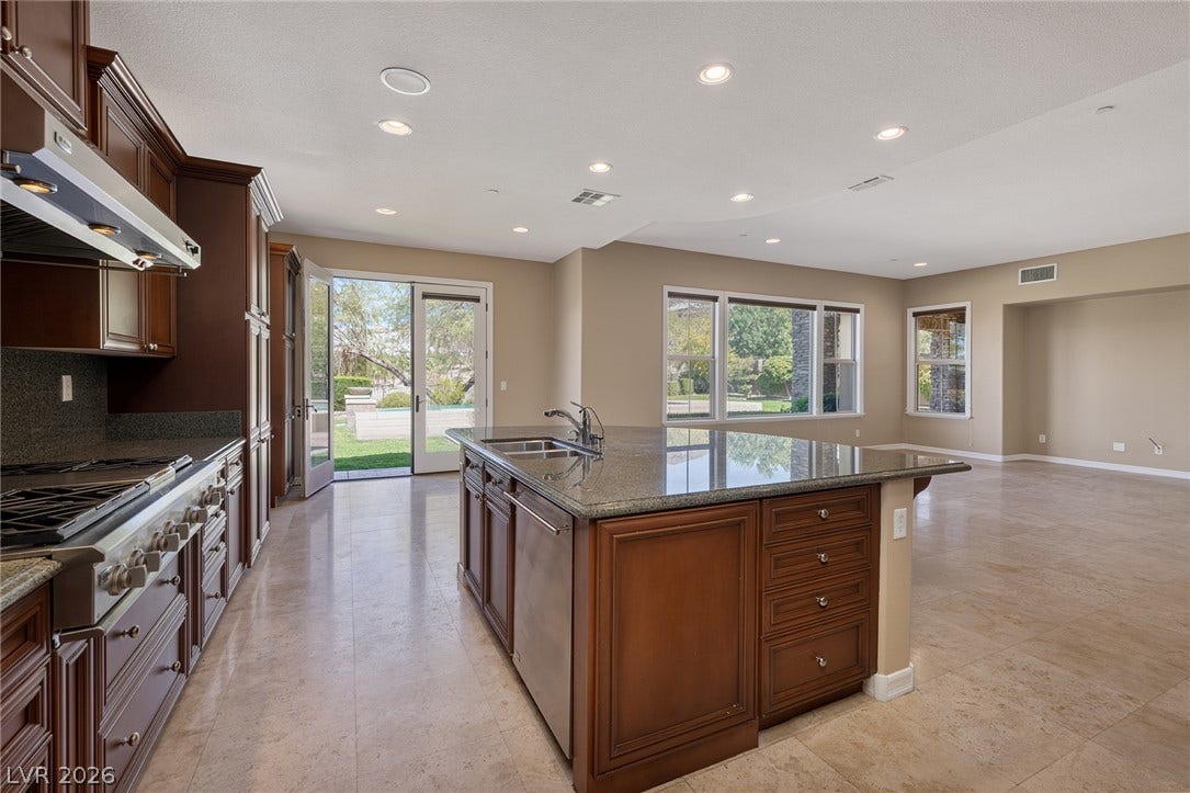 30 Benevolo Drive, Henderson, NV 89011 Culinary aspirations meet luxury in this kitchen featuring a spacious island with granite countertops and direct access to outdoor living.
