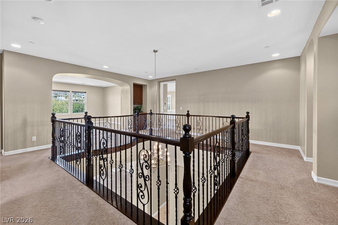 30 Benevolo Drive, Henderson, NV 89011 Ornate wrought iron railings add a touch of elegance to this upper-level hallway overlooking the lower floor.