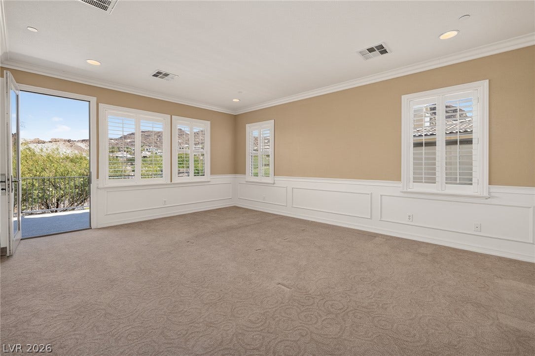 30 Benevolo Drive, Henderson, NV 89011 A room with natural illumination and a carpeted floor opens to a balcony with mountain views.